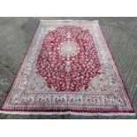 A Persian wool carpet, red ground with ivory border and medallion design - 274 x 185cm
