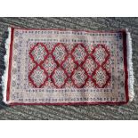 Middle Eastern woollen prayer rug red ground repeating pattern and grey border - 94 x 61cm