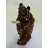 Chinese ceramic figurine of a man holding a fan with red tunic