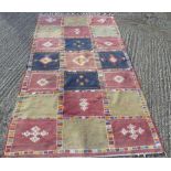 A Moroccan hand made wool rug composed of maroon, green and blue section - 257 x 148cm