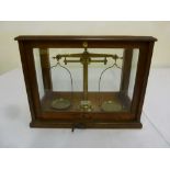 Brass balance scale in glass and oak case