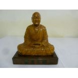 Chinese carved figurine of a seated Buddha on raised rectangular base carved with Chinese characters