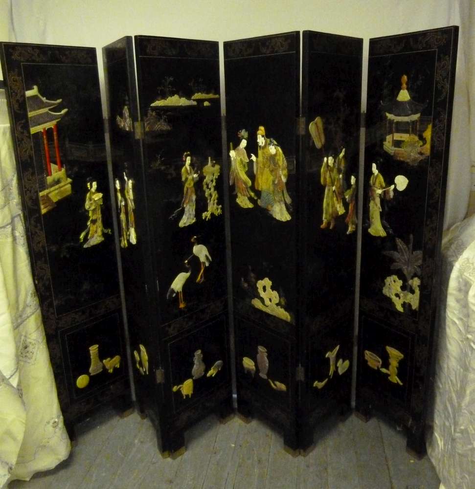 Oriental ebonised six section screen, decorated with carved hardstone figures and buildings