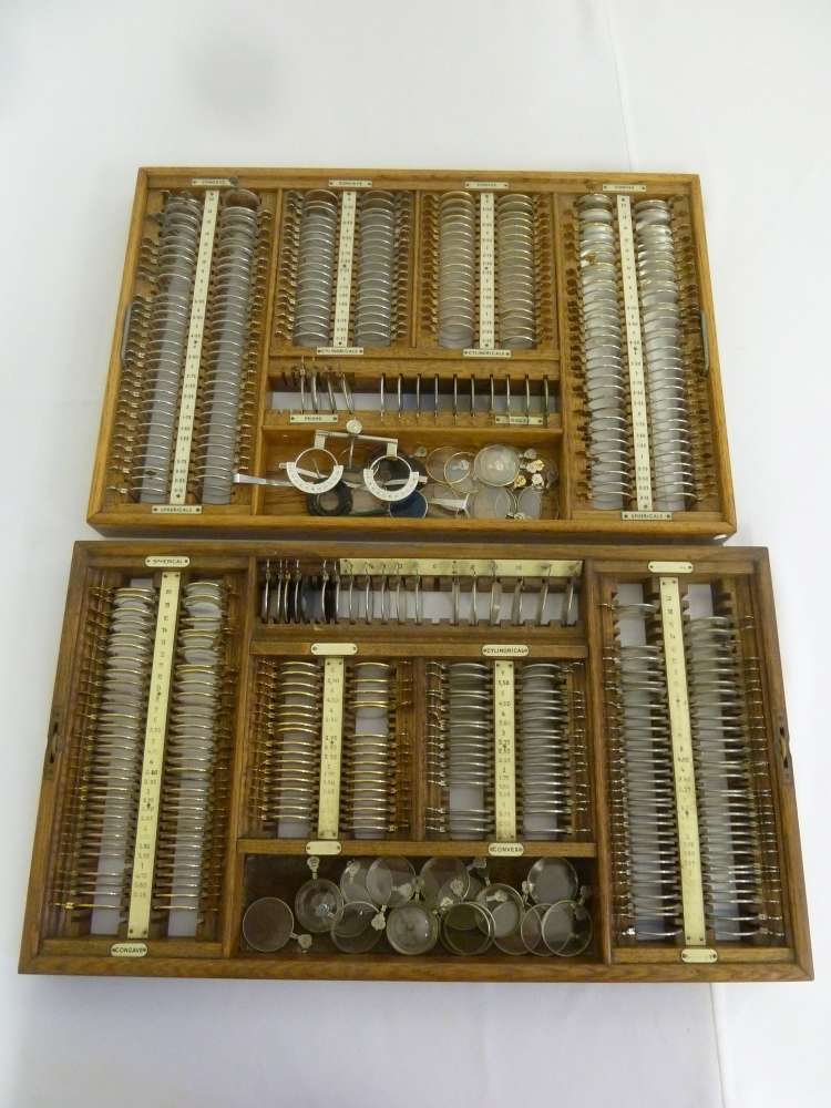 Two trays of antique opticians lenses and accessories