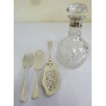 A silver fish slice, a pair of silver plated servers and a decanter with silver collar