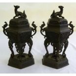 Pair of Oriental bronze incense burners with animal finials on raised hexagonal bases