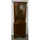 Mahogany corner cabinet with glazed top section and cupboard base on bracket feet