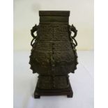 Chinese bronze vase with ring side handles on hardwood stand, the sides chased with stylised scrolls