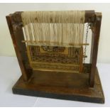 An unusual shopkeepers miniature loom with a part finished rug. Probably North Africa, circa 1900