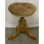 Early 20th century circular upholstered piano stool by Brooks Limited, on three outswept feet