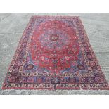 A large Persian wool carpet predominately reds, blues and maroon -318 x 212cm and a wool runner -