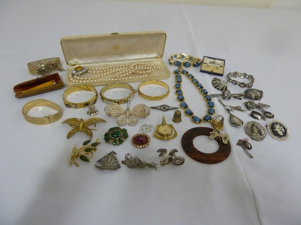 A quantity of costume jewellery to include brooches, necklaces and bangles