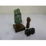 Two stone figurines and a carved wooden Figa