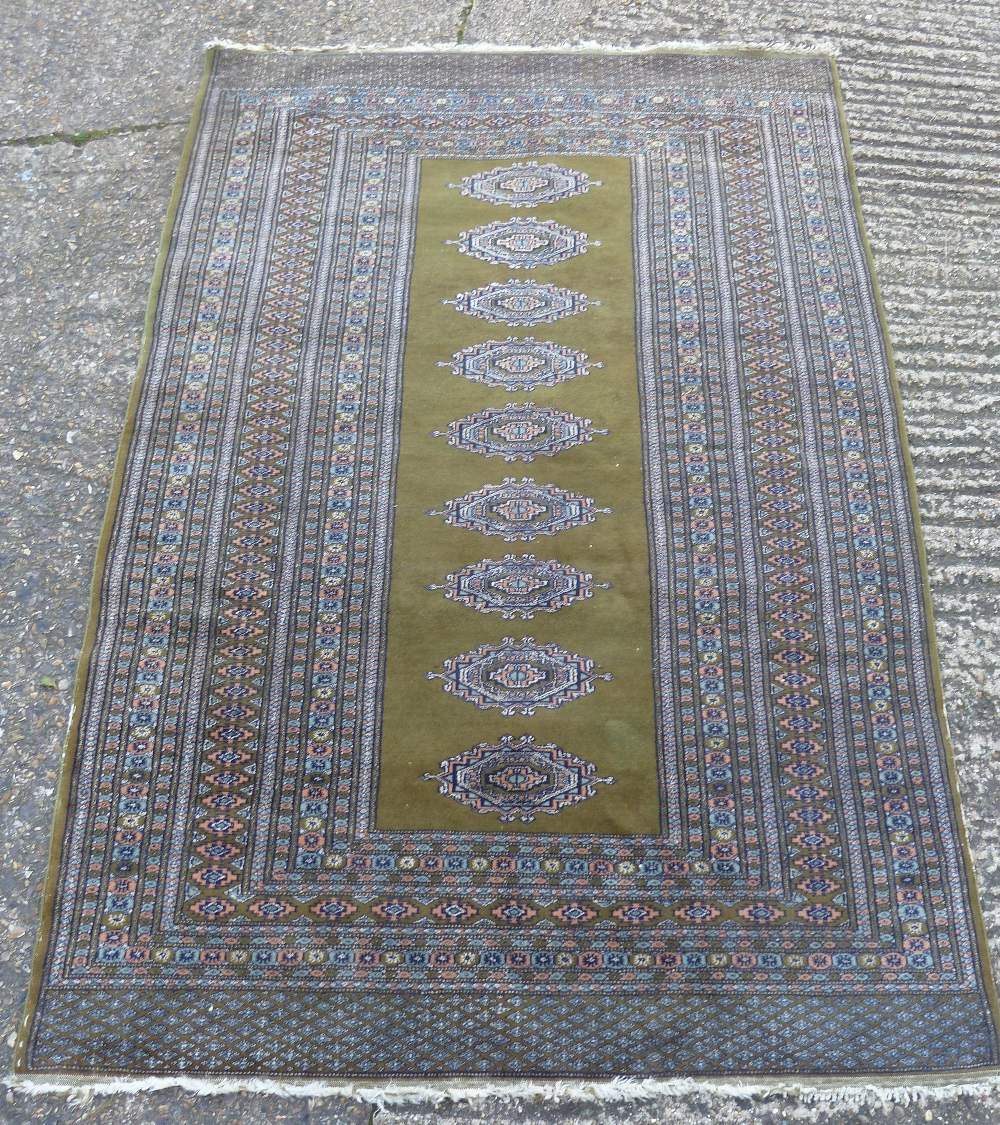 A Kelim style carpet with central medallions against a green ground, 184 x 127cm