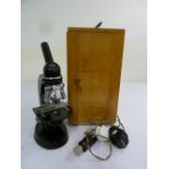 A early 20th century microscope in fitted wooden case to include accessories