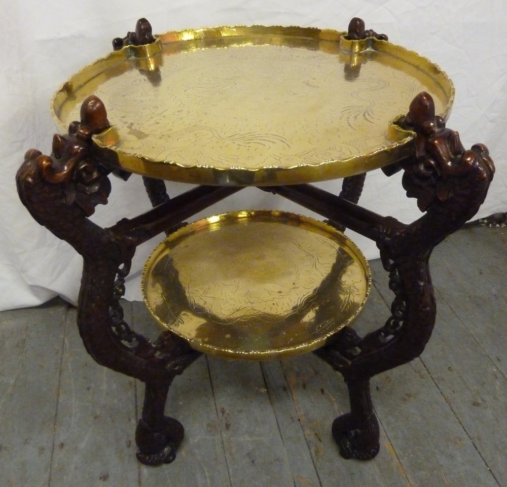 An early 20th century Oriental two tier hardwood stand with detachable engraved brass trays