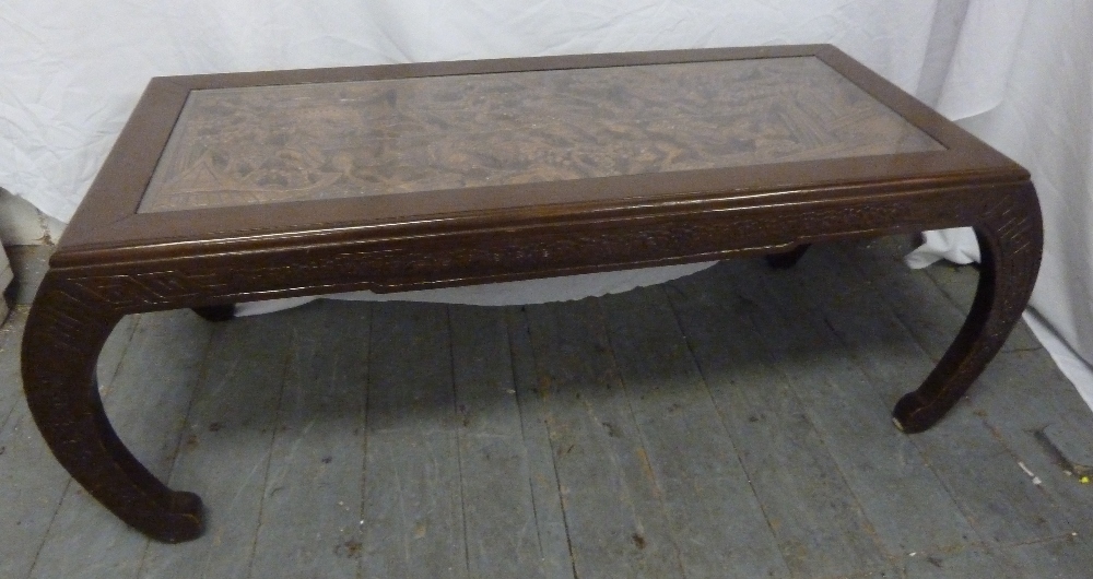 An Oriental hardwood rectangular coffee table with carved top and detachable glass