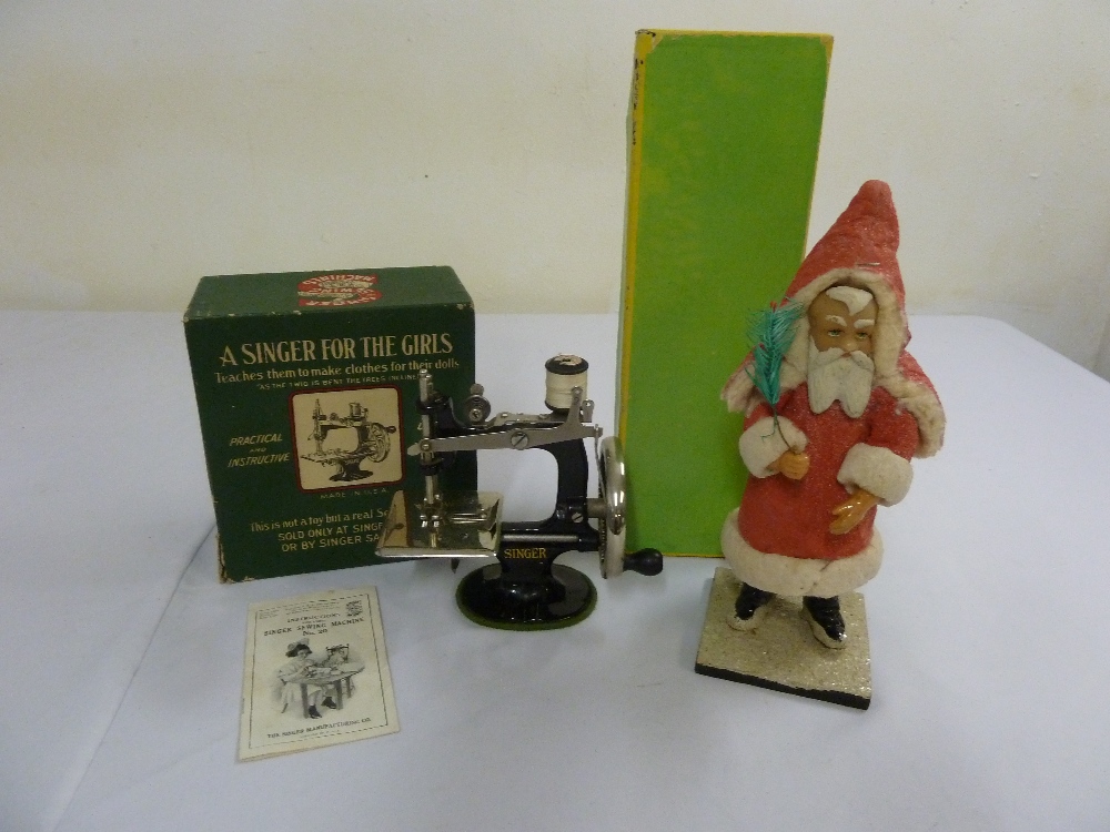 A childs toy Singer sewing machine in original packaging and a1920s figure of Father Christmas in