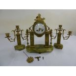 A late 19th century French onyx and brass clock set flanked by three branch candelabra