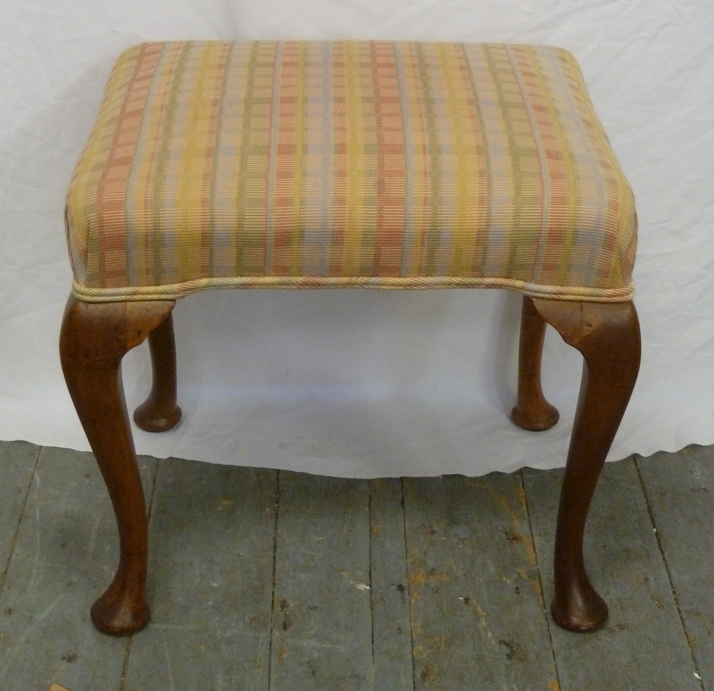 An upholstered Mahogany piano stool on four cabriole legs