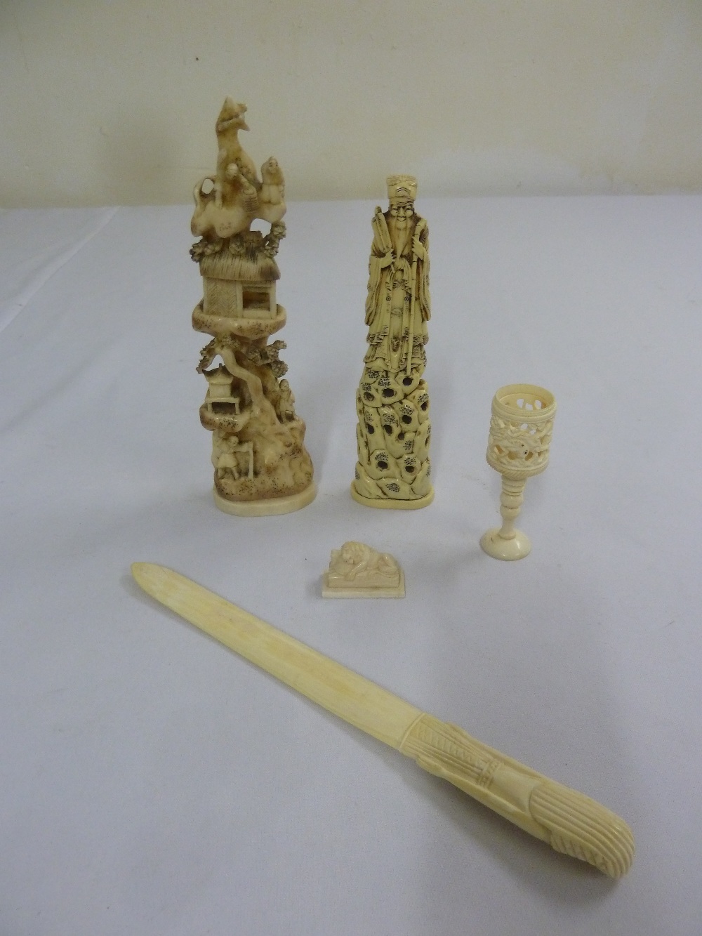 A quantity of early 20th century ivory and bone items to include carved figurines and paper knife