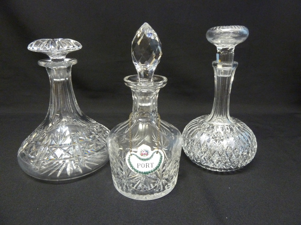 Three cut glass decanters with drop stoppers and a enamel port label