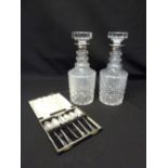 A pair of cut glass decanters with silver collars and a cased set of Aspreys silver teaspoons, A/F