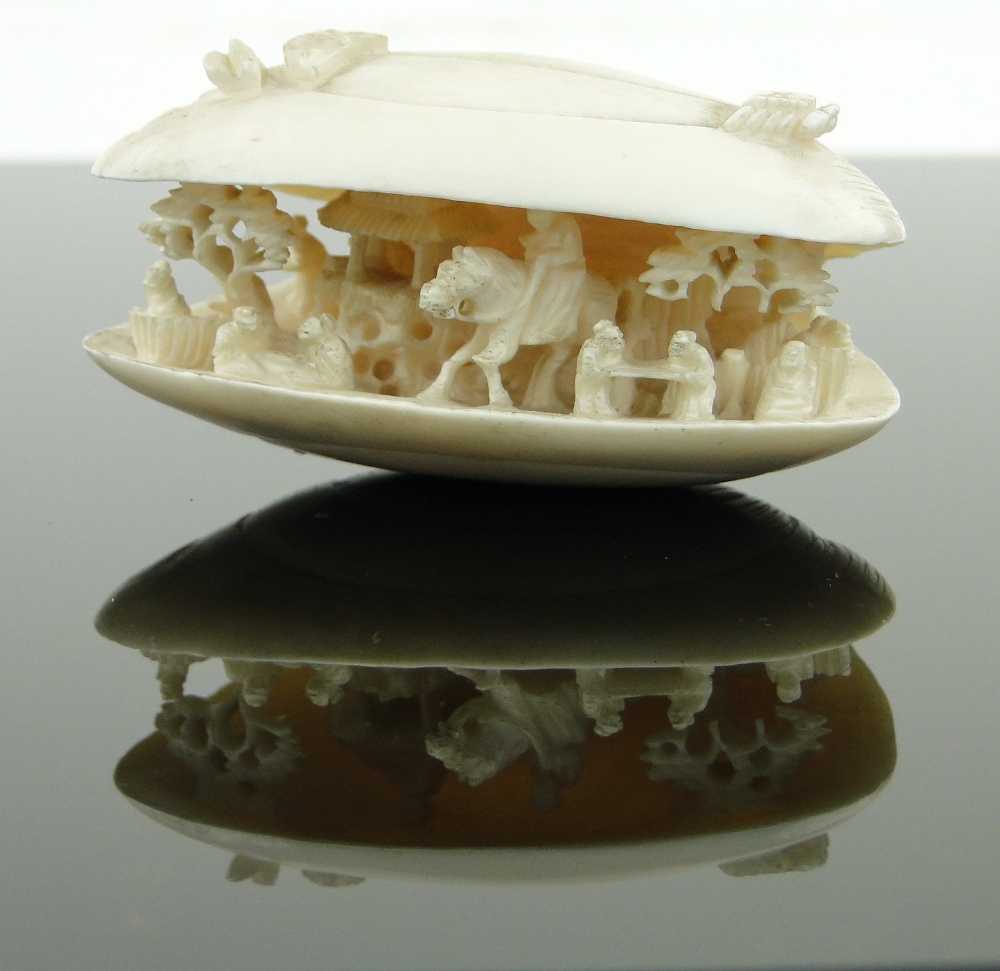 A Chinese carved ivory shell
containing figures and a horseman, length 2.75".
