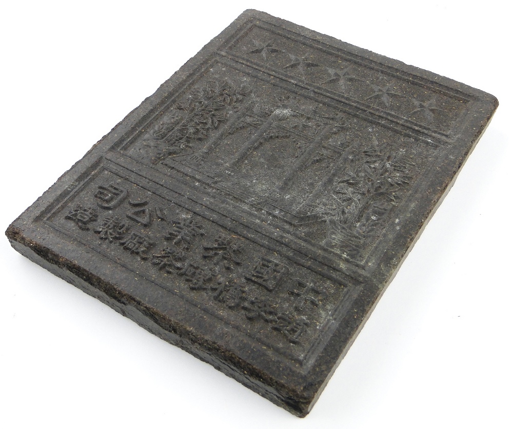 A Chinese pressed tea block
with design of shrine and trees, and script one side and patterned