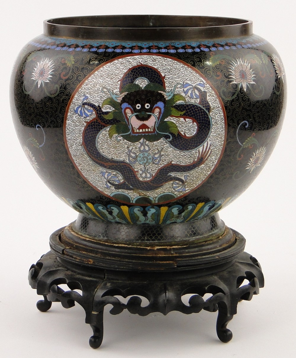 A black ground Cloisonne bowl
with dragon decorated panels, height 9.5", on carved wood stand.