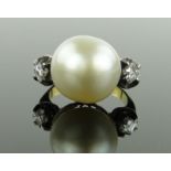 A large pearl set ring,
with princess-cut diamond set shoulders, unmarked gold settings,