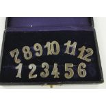 A set of Continental silver wine glass number labels,
1-12, marked 800 in original case.