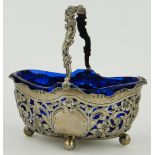 A late Victorian silver swing handled sugar basket,
with pierced sides and blue glass liner,