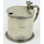 A Victorian silver mustard pot,
with blue glass liner, London 1889.
