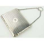 A silver combination notebook/stamp case,
on silver chain, indistinct Birmingham hallmarks,