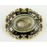 A Victorian gilt metal and enamel memorial brooch with hair panel, 45mm across.