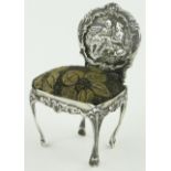 An Edwardian silver dolls house chair,
by William Comyns, London 1902, height 8.5cm.