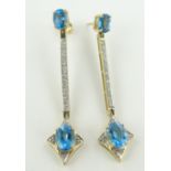Pair of blue topaz and diamond drop earrings,
unmarked gold settings, length 55mm.
