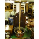 A copper pan with swing handle and a Simplex washing dolly.