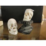 2 carved ivory miniature skulls.