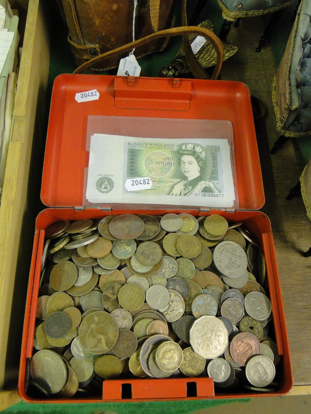 Box of pre-decimal English coins and £1 notes.