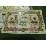 A porcelain desk stand
with painted floral design with 2 inkwells and liners, length 9.5".