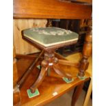 A Regency mahogany revolving piano stool with tapestry top.