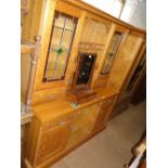 A large modern pine dresser, the top having lead light glazed doors with spice drawers,