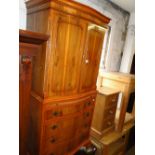 A reproduction yew wood cabinet, with drawers under on bracket feet.