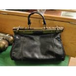 A lady's black leather Gladstone bag.