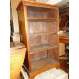 A small mahogany open bookcase with adjustable shelves.