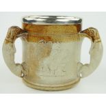 A stoneware harvest tyg
with hound handles and silver plated rim, height 6.5".