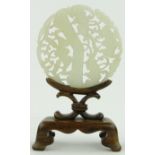 A carved and pierced jade panel
on fitted stand, height 4.75" overall.