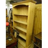 A large floor standing open pine bookcase.